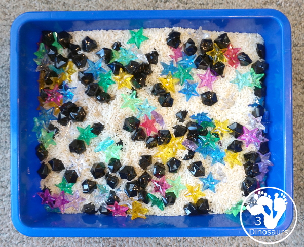 Star Sensory Bin For a Space Theme for kids in preschool, prek and kindergarten. A fun and easy to set up sensory bin with stars, black rocks and rice for base for a space theme - 3Dinosaurs.com