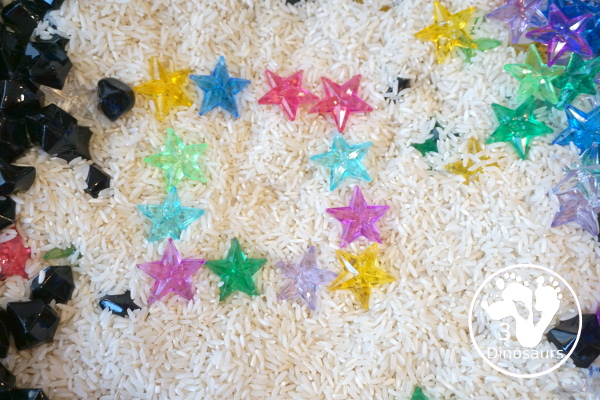 Star Sensory Bin For a Space Theme for kids in preschool, prek and kindergarten. A fun and easy to set up sensory bin with stars, black rocks and rice for base for a space theme - 3Dinosaurs.com