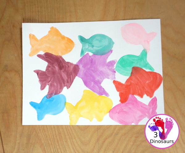Fish Watercolor Painting with Cookie Cutters is an easy ocean fish painting you can do with kids. You can use one cookie cutter or several fish cookie cutters to make  the painting  - 3Dinosaurs.com
