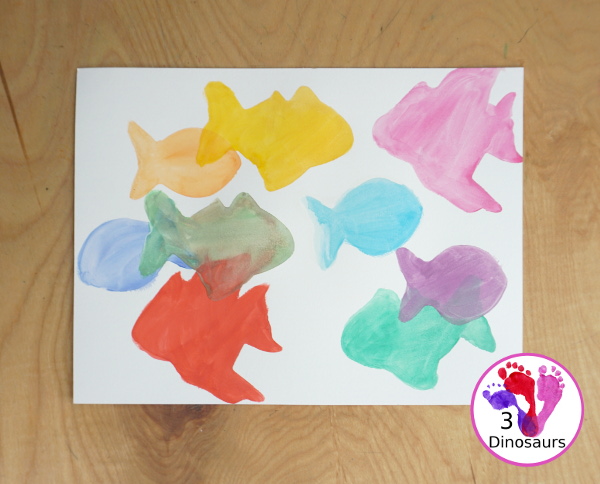 Fish Watercolor Painting with Cookie Cutters is an easy ocean fish painting you can do with kids. You can use one cookie cutter or several fish cookie cutters to make  the painting  - 3Dinosaurs.com