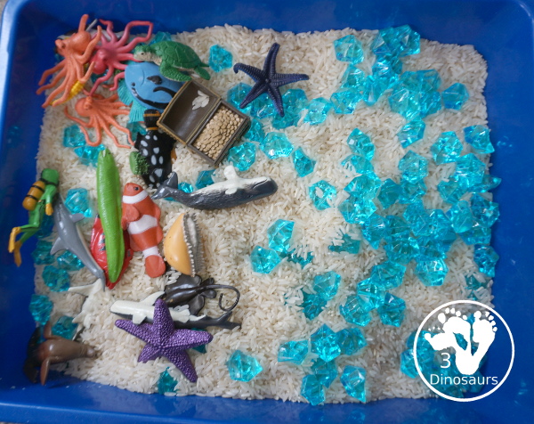 Ocean Rice and Rock Sensory Bin - a simple rice base sensory bin that has ocean animals and blue acrylic rocks in the bin. A simple sensory bin for any ocean theme - 3Dinosaurs.com