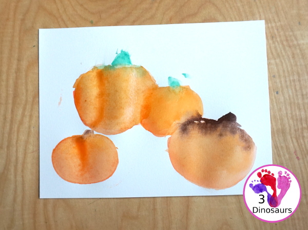 Pumpkin Cookie Cutter Watercolor Painting - a fun watercolor painting activity with pumpkin cookie cutters to make the pumpkins. Simple pumpkin paintings that different ages can do. - 3Dinosaurs.com