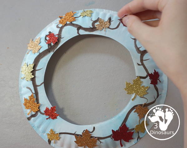 Fall Leaf Wreath Craft for Kids with a watercolor painted paper plate and leaves made from glitter paper - 3Dinosaurs.com