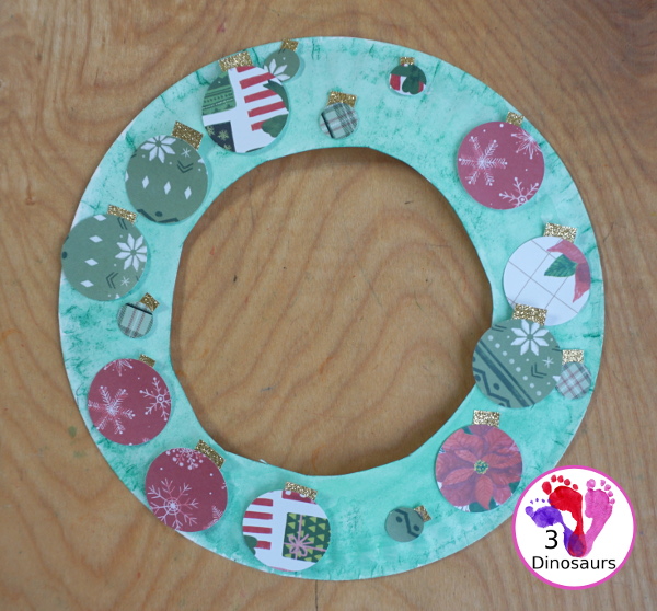 Christmas Wreath With Scrapbook Ornaments For Kids is a super easy Christmas wreath you can make with kids with a few simple items. - 3Dinosaurs.com