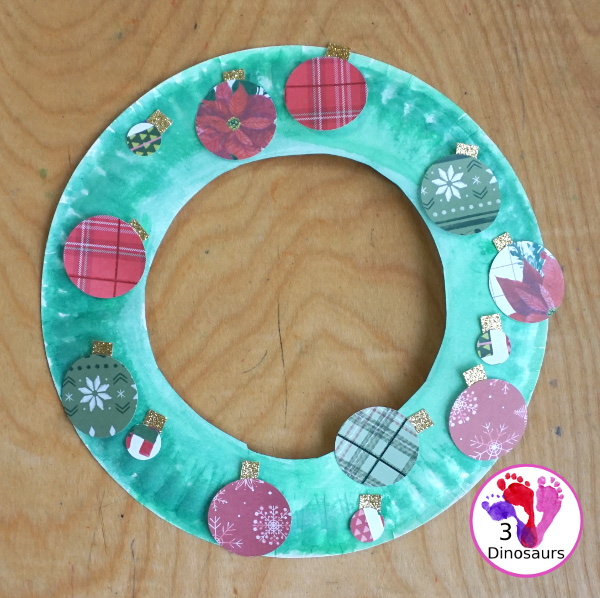 Christmas Wreath With Scrapbook Ornaments For Kids is a super easy Christmas wreath you can make with kids with a few simple items. - 3Dinosaurs.com