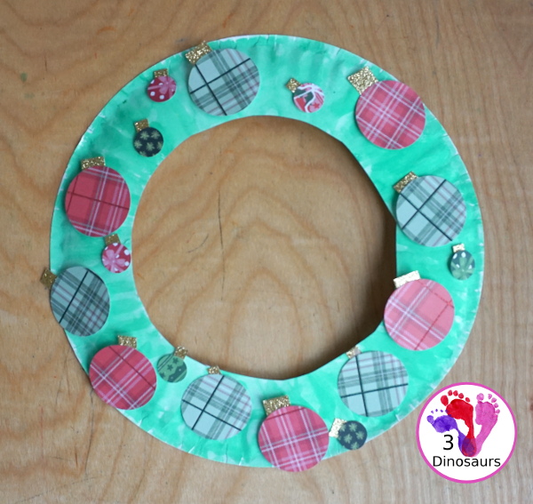 Christmas Wreath With Scrapbook Ornaments For Kids is a super easy Christmas wreath you can make with kids with a few simple items. - 3Dinosaurs.com