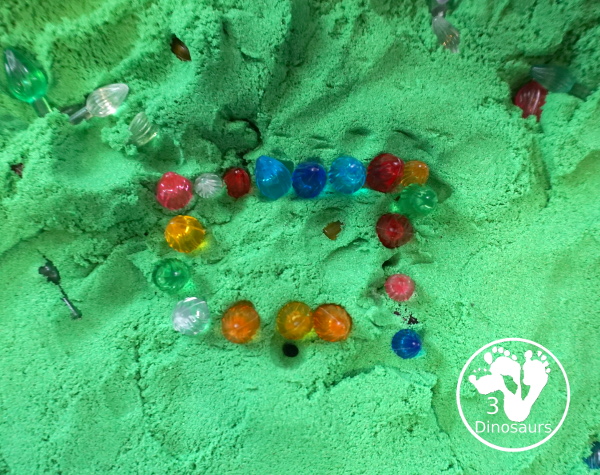 Christmas Lights and Kinetic Sand Sensory Bin - a fun sensory bin with green kinetic sand and Christmas lights for kids to play in and explore. - 3Dinosaurs.com