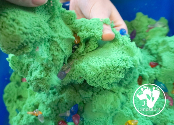 Christmas Lights and Kinetic Sand Sensory Bin - a fun sensory bin with green kinetic sand and Christmas lights for kids to play in and explore. - 3Dinosaurs.com