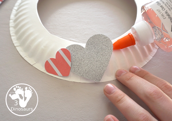 Valentines Heart Wreaths with Scrapbook Paper a fun paper plate wreath made using a heart punch and loads of fun for Valentines Day - 3Dinosaurs.com