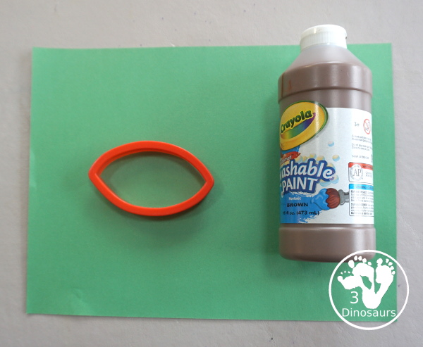 Football Stamp Painting with Cookie Cutters - You use a football shape cookie cutter to stamp brown footballs all over a green paper - 3Dinosaurs.com