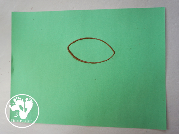 Football Stamp Painting with Cookie Cutters - You use a football shape cookie cutter to stamp brown footballs all over a green paper - 3Dinosaurs.com