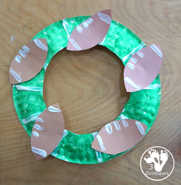 Football Wreath Craft For Kids - a fun wreath craft for a football theme. You have a green wreath with white lines and footballs around the wreath. Great for any football theme. - 3Dinosaurs.com