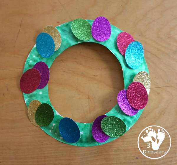 Glitter Easter Egg Wreath Craft - a fun Easter Egg wreath made with a paper plate and ovals for the eggs - 3Dinosaurs.com