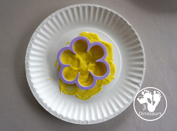 Flower Stamp Painting With Cookie Cutters - cookie cutter in the paint on the paper plate 3Dinosaurs.com