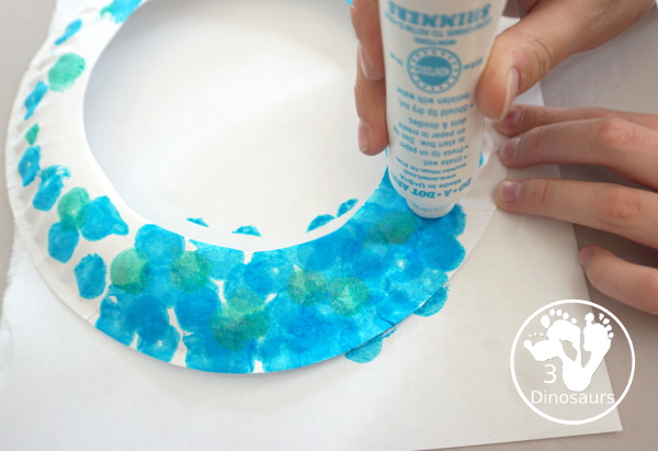 Ocean Wreath with Glitter Fish - A great wreath you can make with an ocean theme. It is a simple and easy-to-make craft for kids of different ages. You have a paper plate, glitter paper, glue and fish punches. - 3Dinosaurs.com