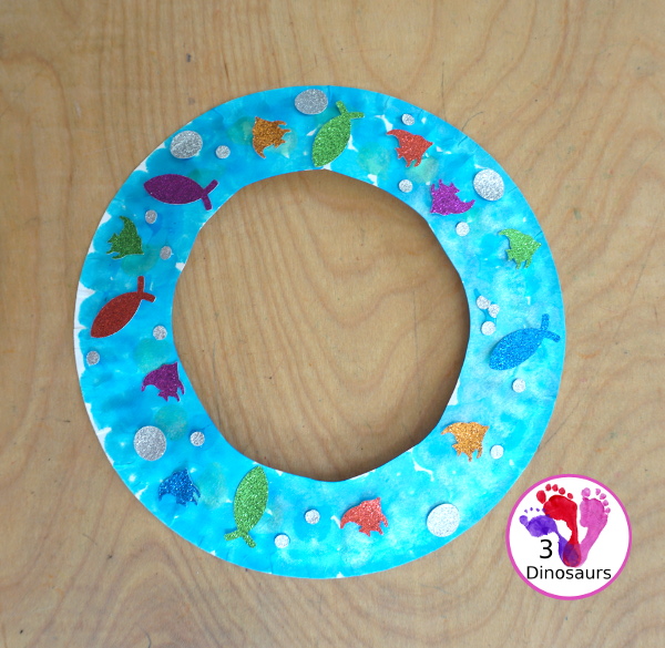 Ocean Wreath with Glitter Fish - A great wreath you can make with an ocean theme. It is a simple and easy-to-make craft for kids of different ages. You have a paper plate, glitter paper, glue and fish punches. - 3Dinosaurs.com