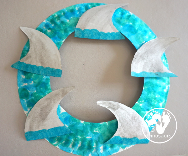 Shark Fin Wreath Craft for Shark Week - that kids can make with a shark cookie cutter and a paper plate. A super easy wreath for all ages.-  3Dinosaurs.com