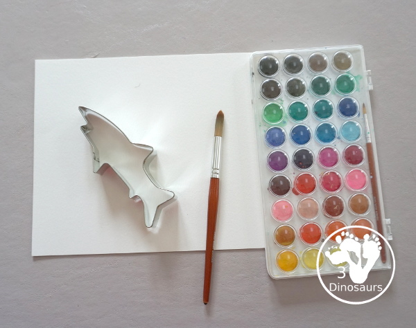 Shark Watercolor Painting with Cookie Cutters - a fun shark painting activity that you can do with kids for shark week. You use shark cookie cutter and watercolors - 3Dinosaurs.com