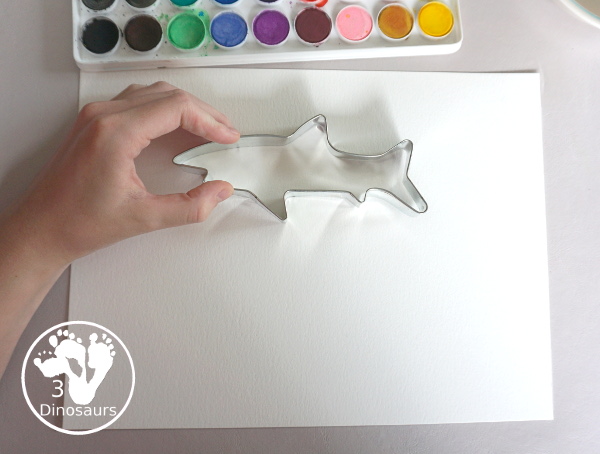 Shark Watercolor Painting with Cookie Cutters - a fun shark painting activity that you can do with kids for shark week. You use shark cookie cutter and watercolors - 3Dinosaurs.com