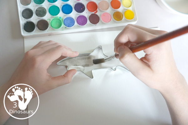 Shark Watercolor Painting with Cookie Cutters - a fun shark painting activity that you can do with kids for shark week. You use shark cookie cutter and watercolors - 3Dinosaurs.com