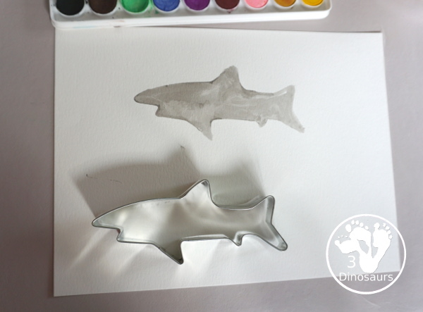 Shark Watercolor Painting with Cookie Cutters - a fun shark painting activity that you can do with kids for shark week. You use shark cookie cutter and watercolors - 3Dinosaurs.com