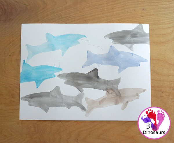 Shark Watercolor Painting with Cookie Cutters - a fun shark painting activity that you can do with kids for shark week. You use shark cookie cutter and watercolors - 3Dinosaurs.com