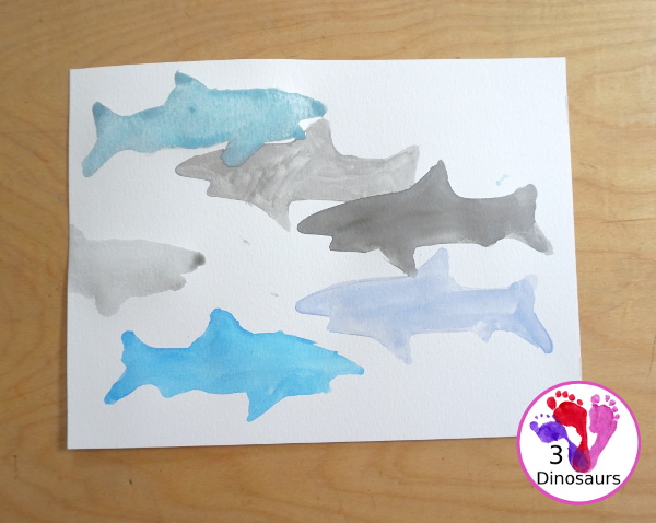 Shark Watercolor Painting with Cookie Cutters - a fun shark painting activity that you can do with kids for shark week. You use shark cookie cutter and watercolors - 3Dinosaurs.com